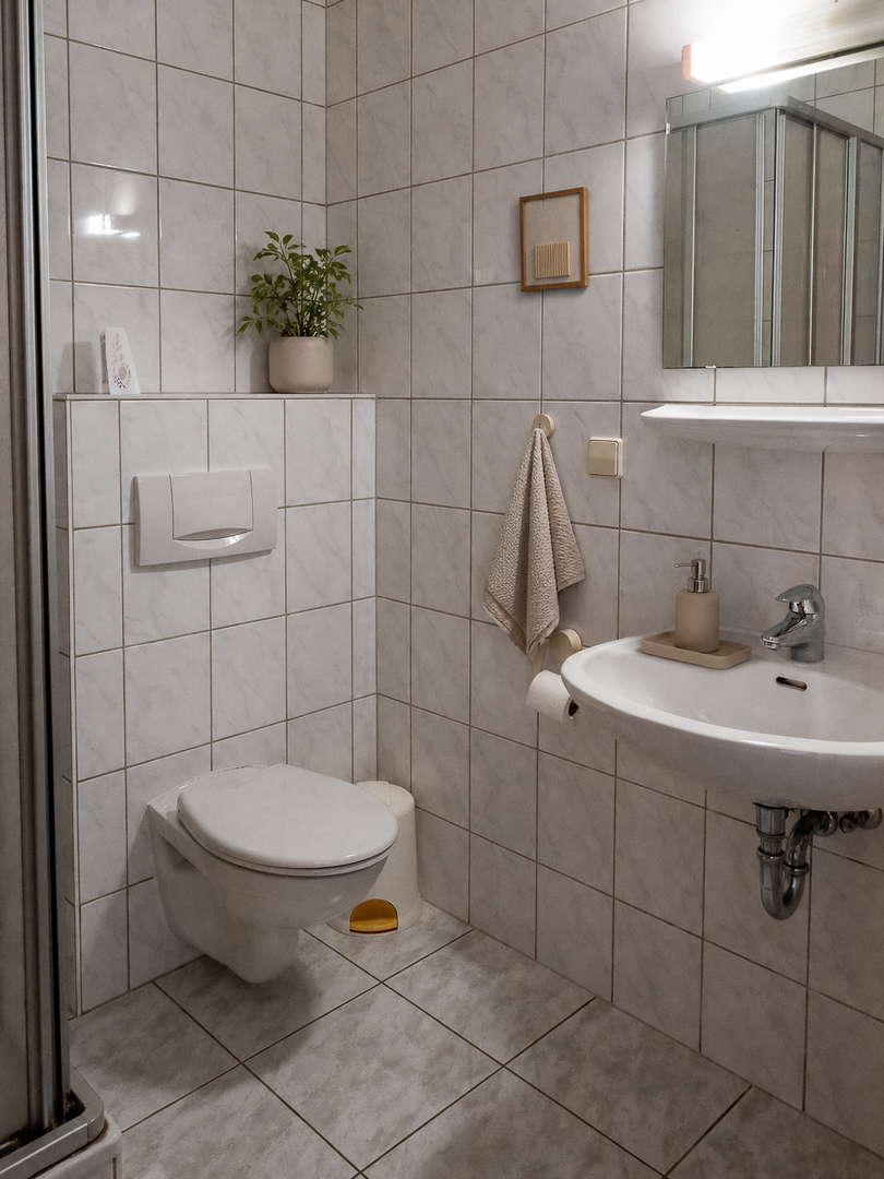 Gefliestes Bad mit Dusche und WC