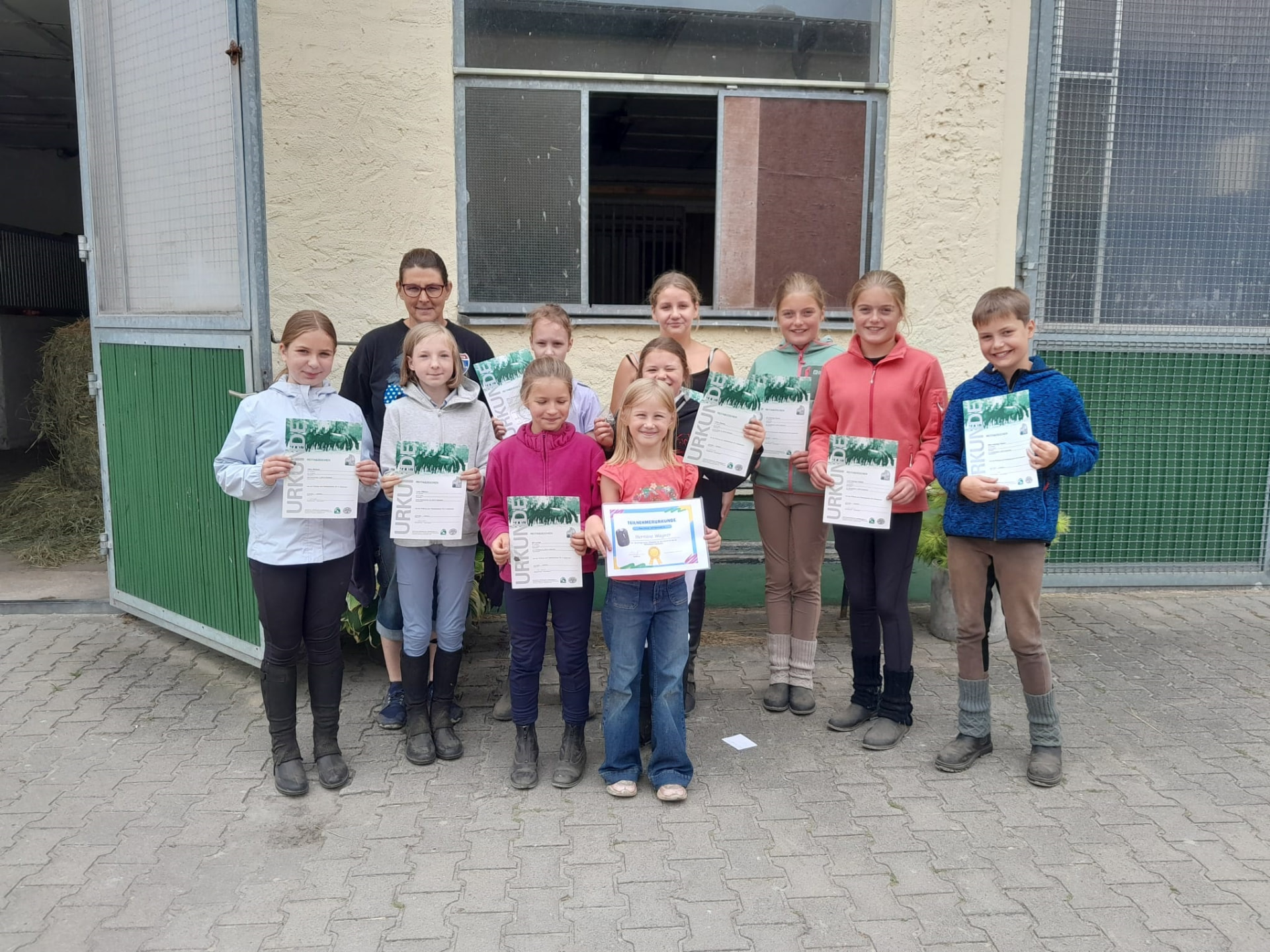 Kindergruppe mit Urkunden vor dem Stall